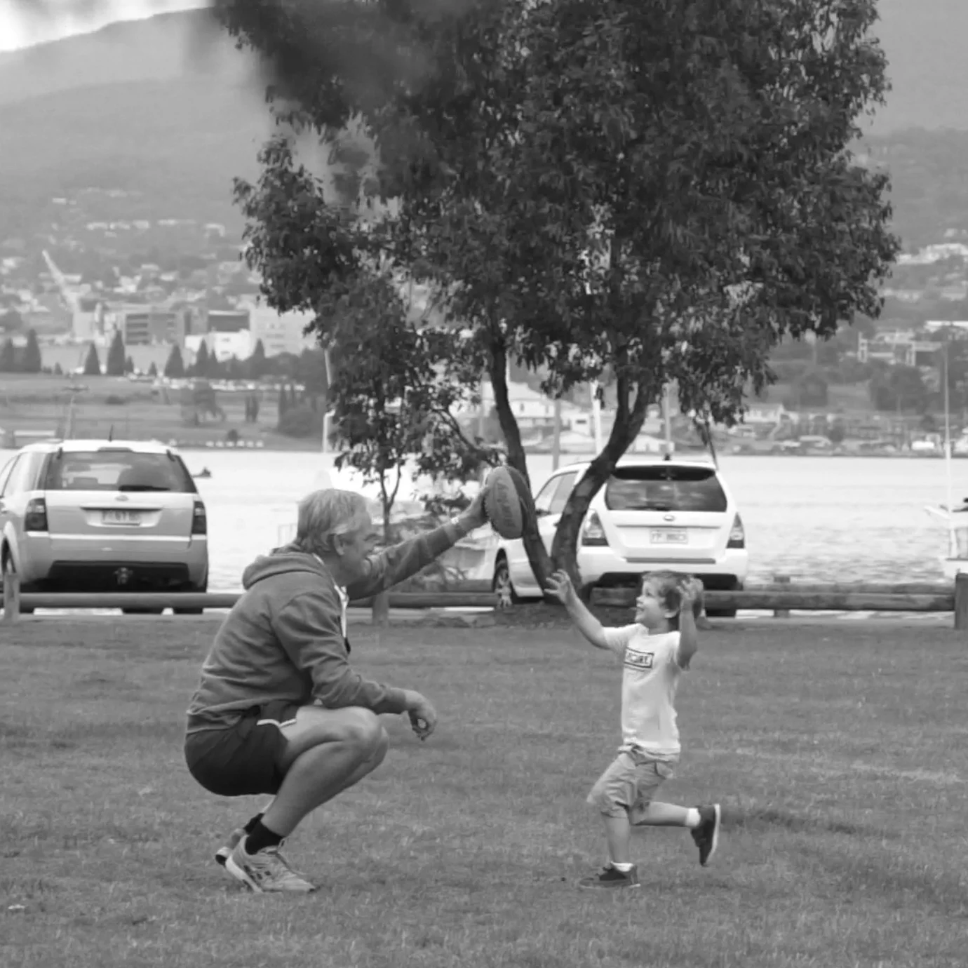 Father and child playing in a park. Real Estate Greater Hobart