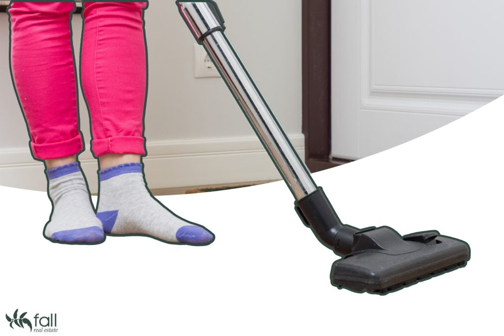 Image for blog: Looking after your rental property. Image depicts a close up shot of a person's legs and a vacuum cleaner