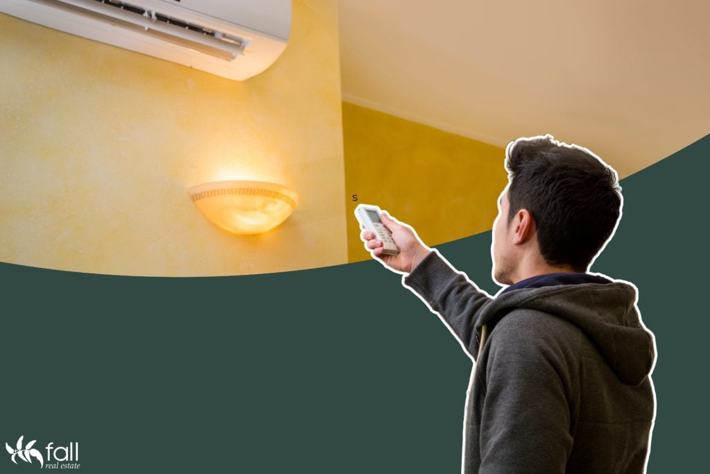 Image of a man playing with his air conditioner. Is he turning it up because of winter? Or turning it down because of summer?